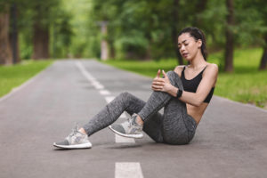 A young woman takes a break from running due to a knee problem